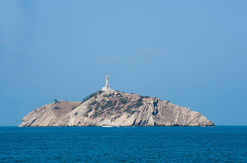 Panorámica del morro, una isla rocosa en medio del mar con un faro 